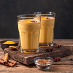 two-glasses-coffee-with-milk-turmeric-wooden-background_166116-5123_medium